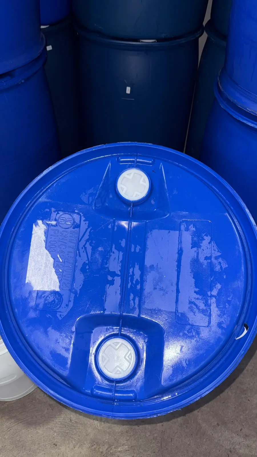 Tampa de bombona plástica azul de 200 litros vista de cima, com as duas boquinhas de rosca