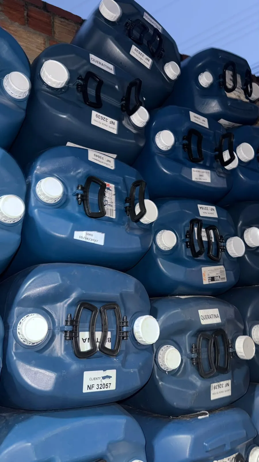 Bombonas de 50 litros usadas e revisadas, organizadas em pilhas no estoque