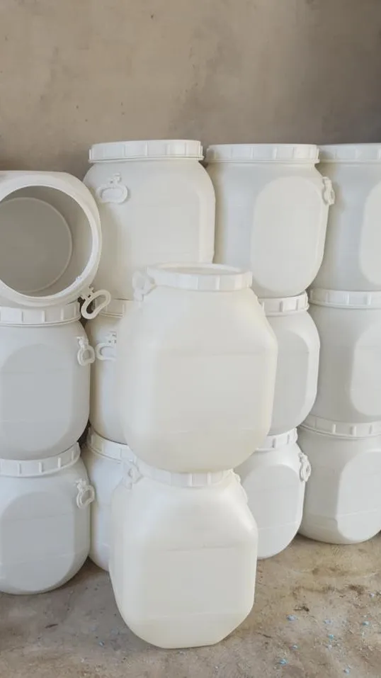 Tambores plásticos brancos de 50 litros com boca larga, tampa de rosca e alças, empilhados no estoque